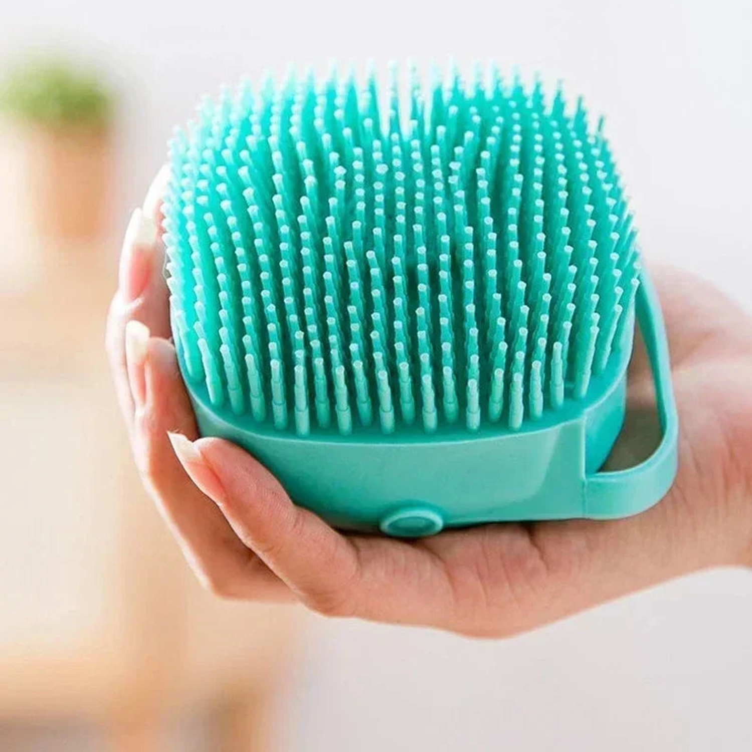 Hand holding a mint silicone dog bath brush showing dense soft massage bristles