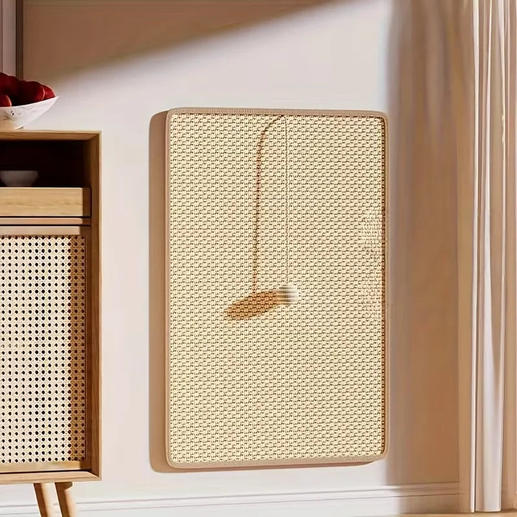 Sisal cat scratching post mat mounted flat on a wall with its hanging bead toy in a sunlit living room
